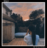 a woman is taking a picture of a sunset on a deck