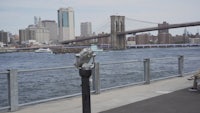 a man sitting on a bench next to a body of water