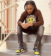 a young man sitting on stairs with a smile on his face