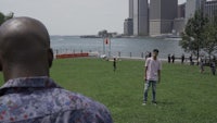 a man is standing in a park with a frisbee in his hand