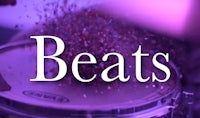 a person is playing a drum with the words beats on it